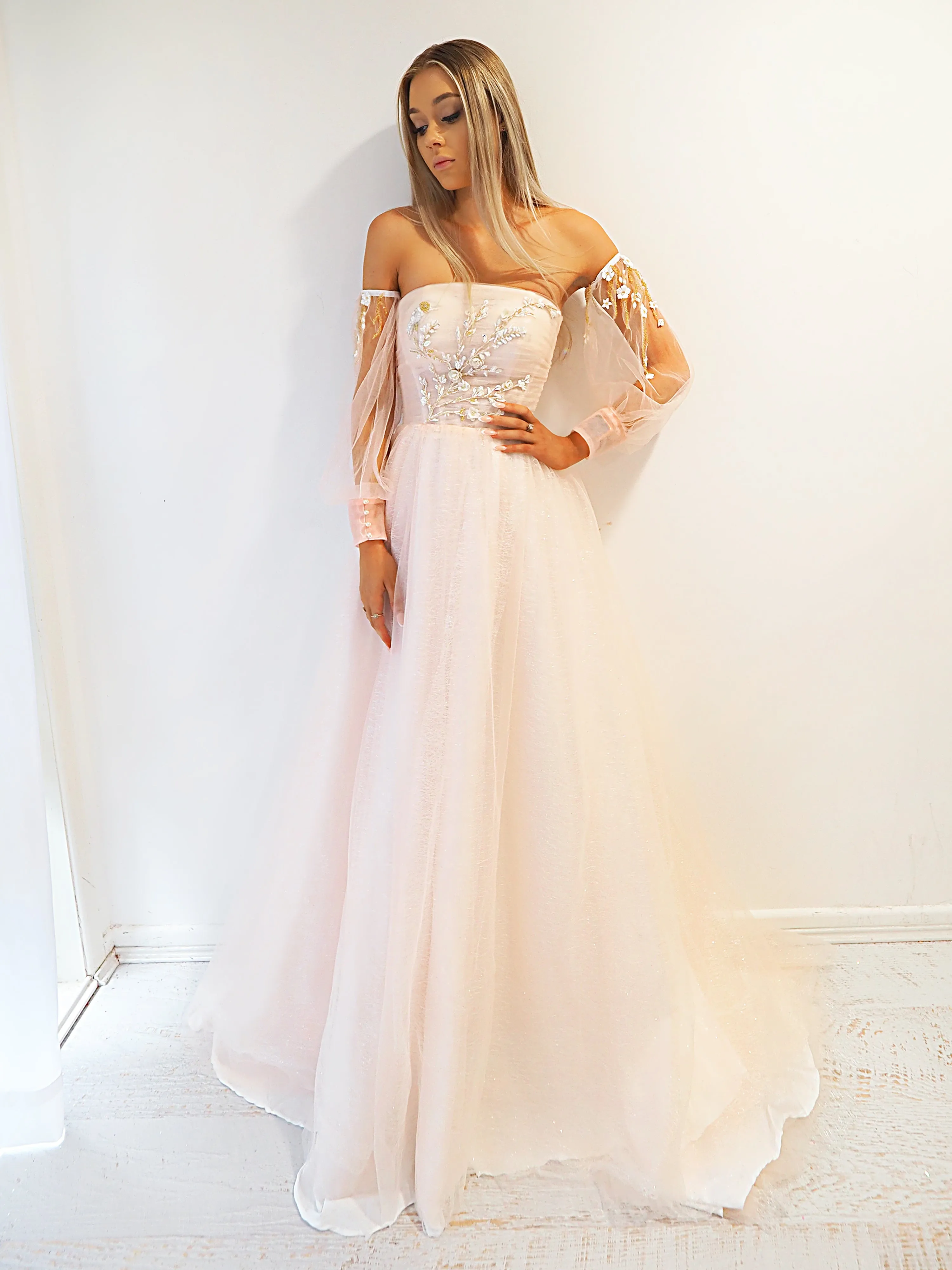 Pastel pink accent straight neck line with a pastel pink flowy skirt and long sleeves.